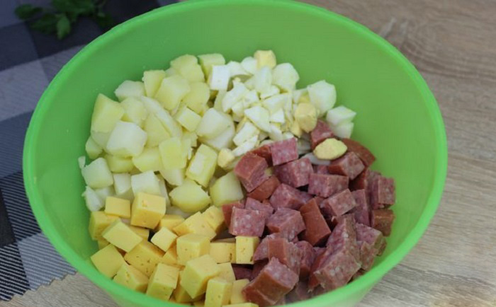 Смешивание ингредиентов салата из колбасы