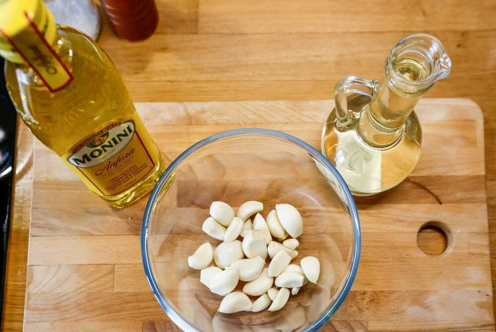 На деревянном столе ингредиенты для маринада: чеснок, мало