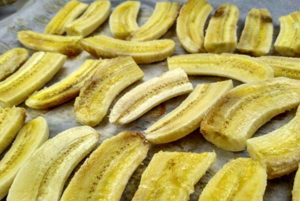 Нарезанные бананы разложены на противне 