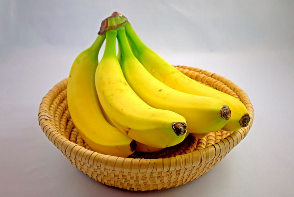 В корзине лежит связка свежих бананов