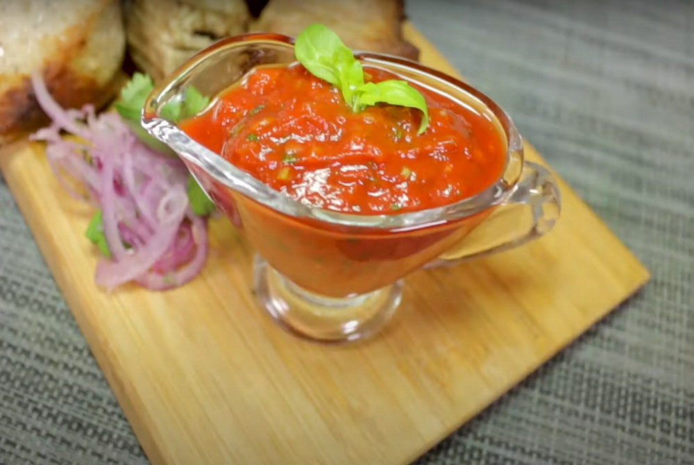 На деревянной доске томатный соус с базиликом 