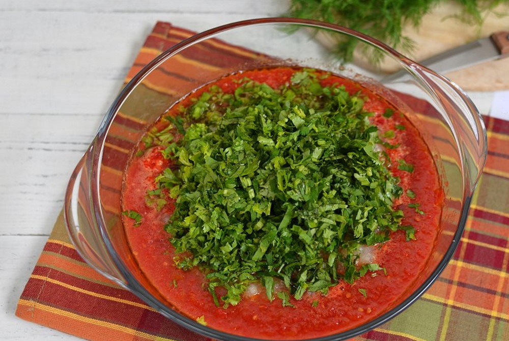 В прозрачной миске томатная паста с зеленью