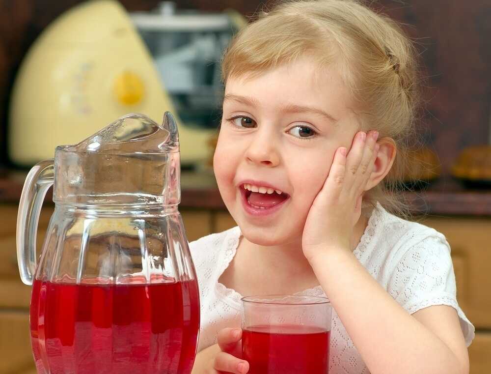 Девочка пьет напиток из боярышника