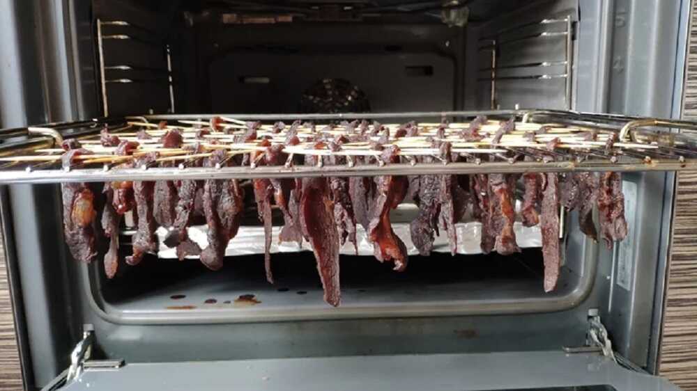 Кусочки говядины подвешены на решетке в духовке