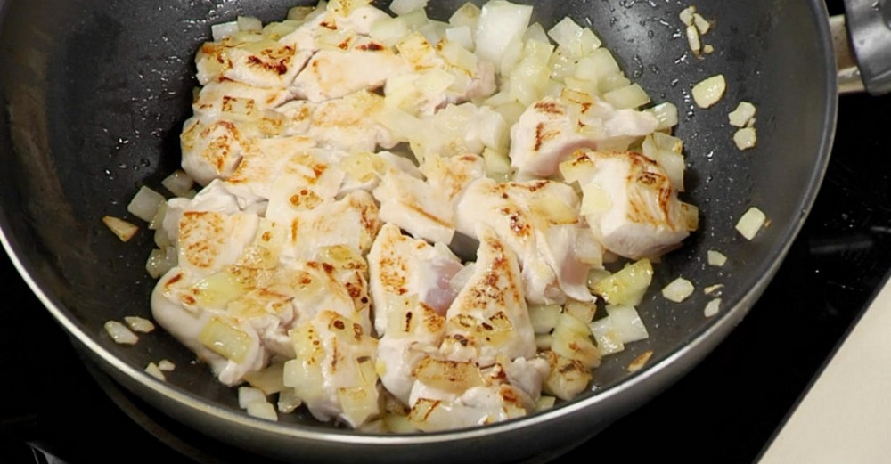 Курица с луком жарится на сковороде