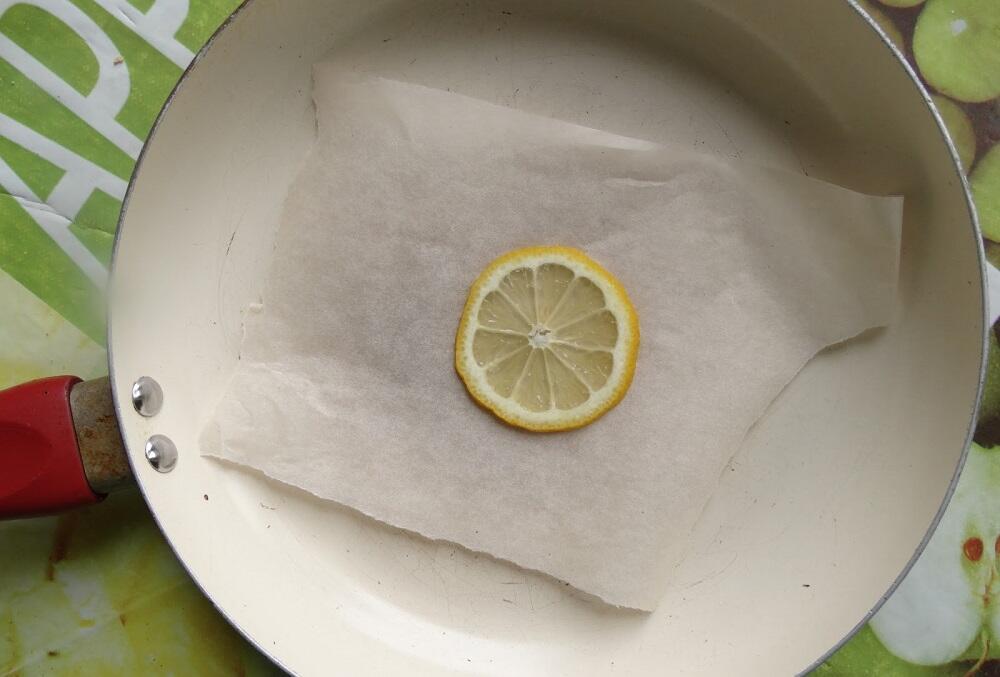 Кусочек лимона на бумаге в сковороде