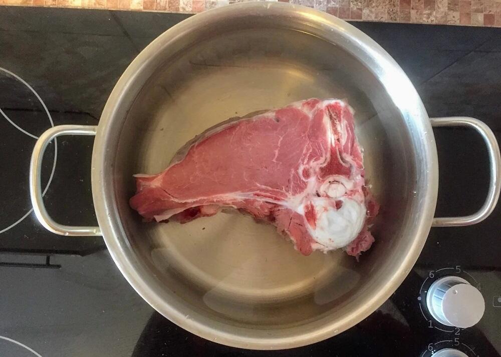 Кусок мяса в кастрюле с водой
